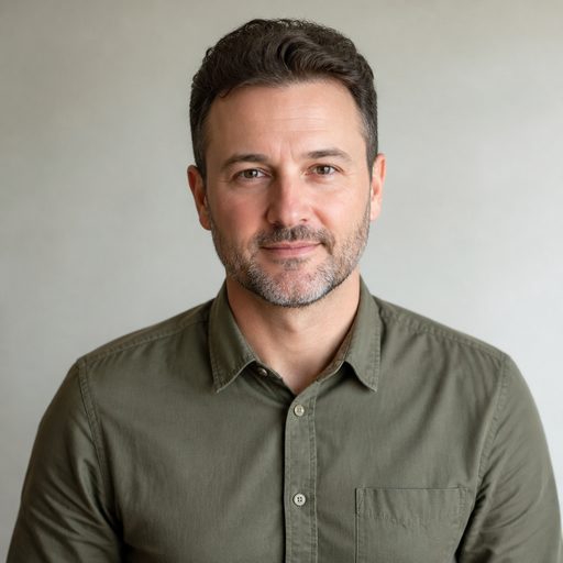 Middle-aged man with short beard, professional headshot, soft grey background