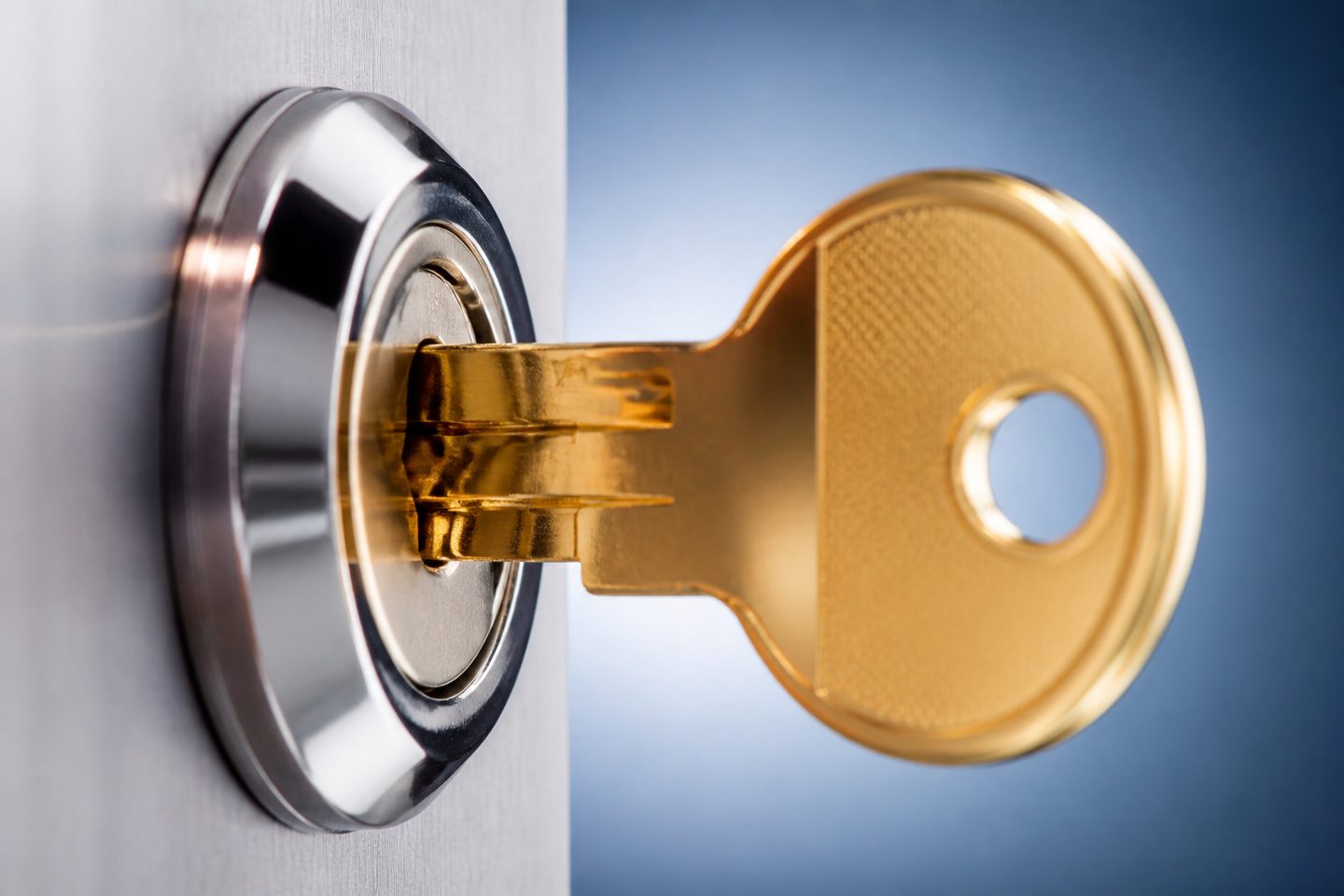 Brand new high-security cylinder lock mounted on a metal door, shiny brass key inserted, close-up detail